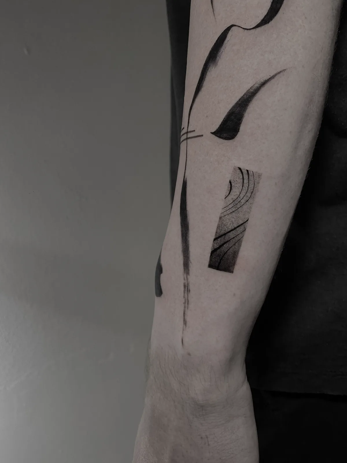 Bold abstract blackwork shapes down the arm, GAR Tattoo