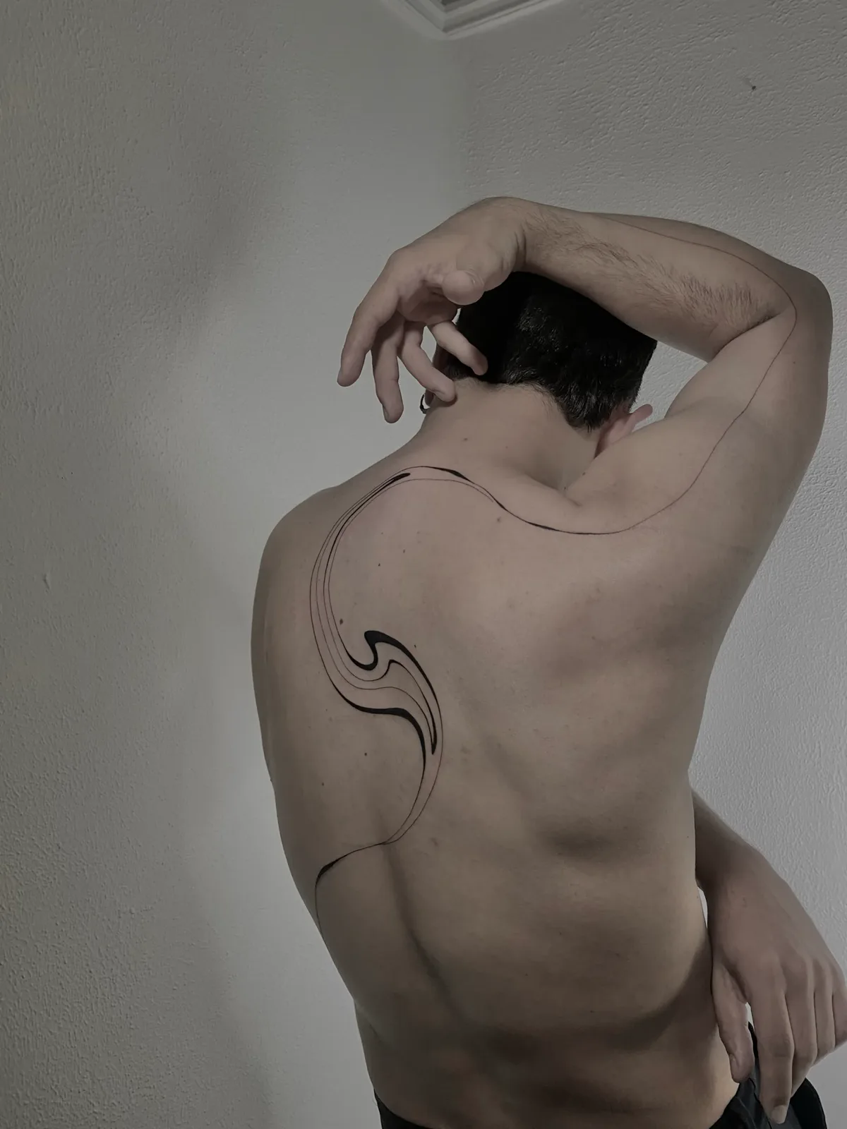 Liquid minimalist blackwork flowing across the full back, GAR Tattoo