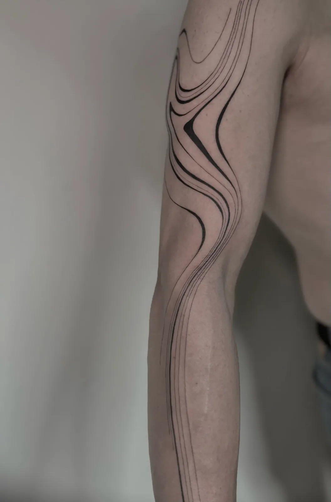 Liquid minimalist blackwork running the length of the leg, GAR Tattoo