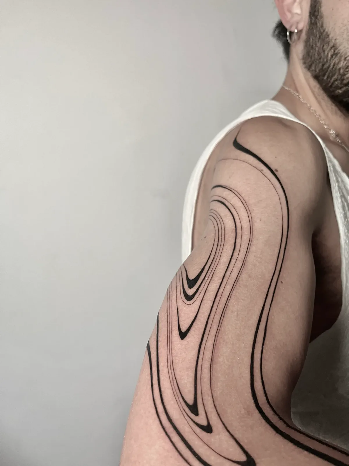 Liquid minimalist blackwork wrapping the ribs and side, GAR Tattoo