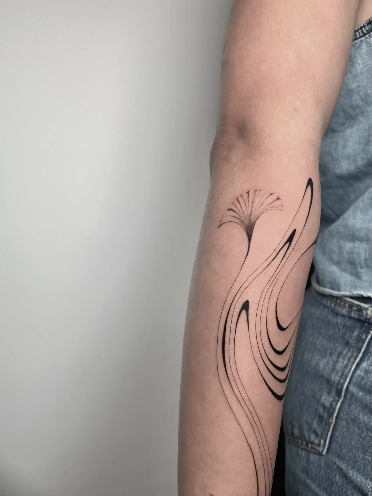 Fine-line dandelion fused with a flowing line on the forearm, GAR Tattoo