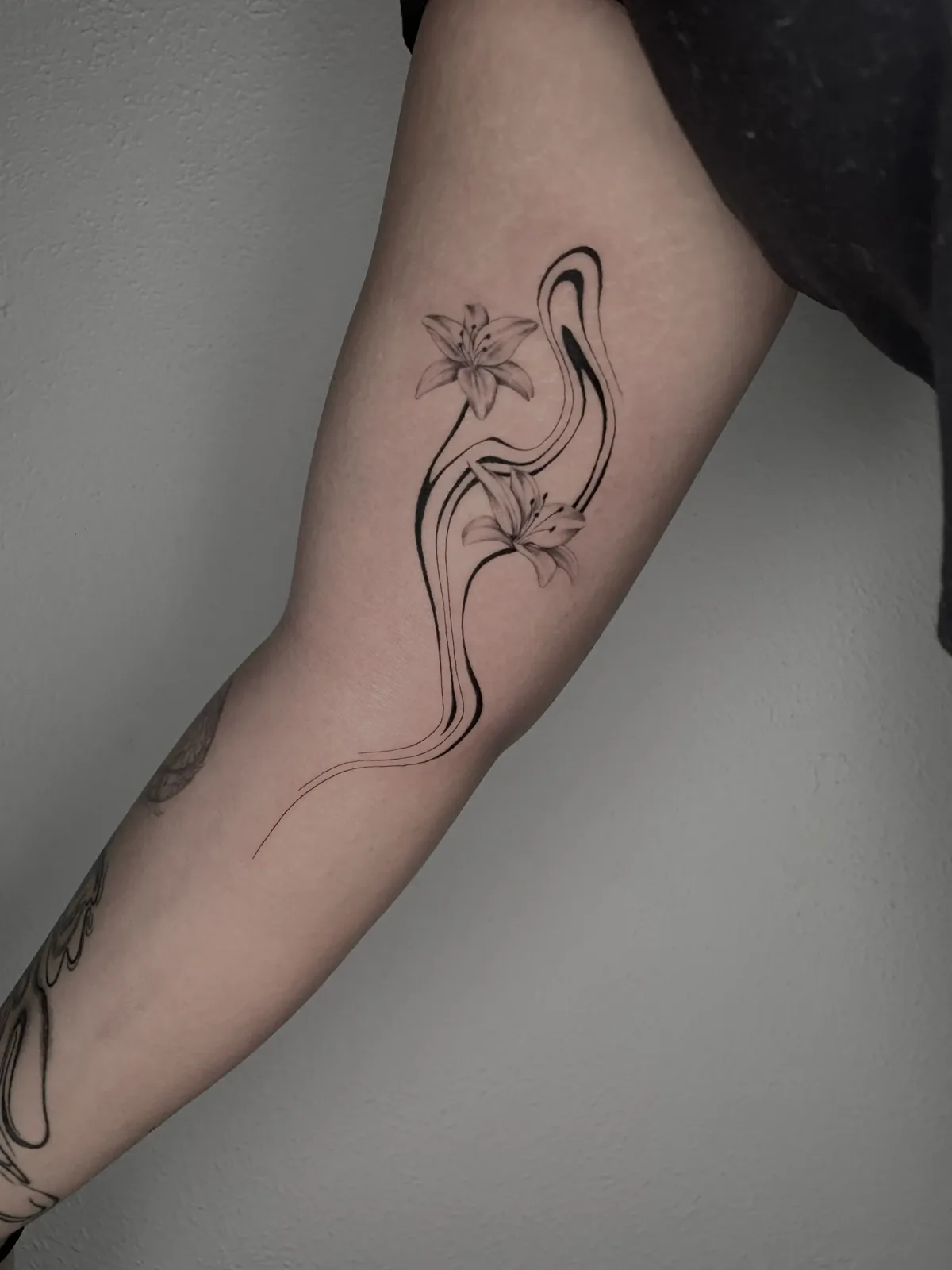 Botanical florals fused with liquid line flowing down the arm, GAR Tattoo