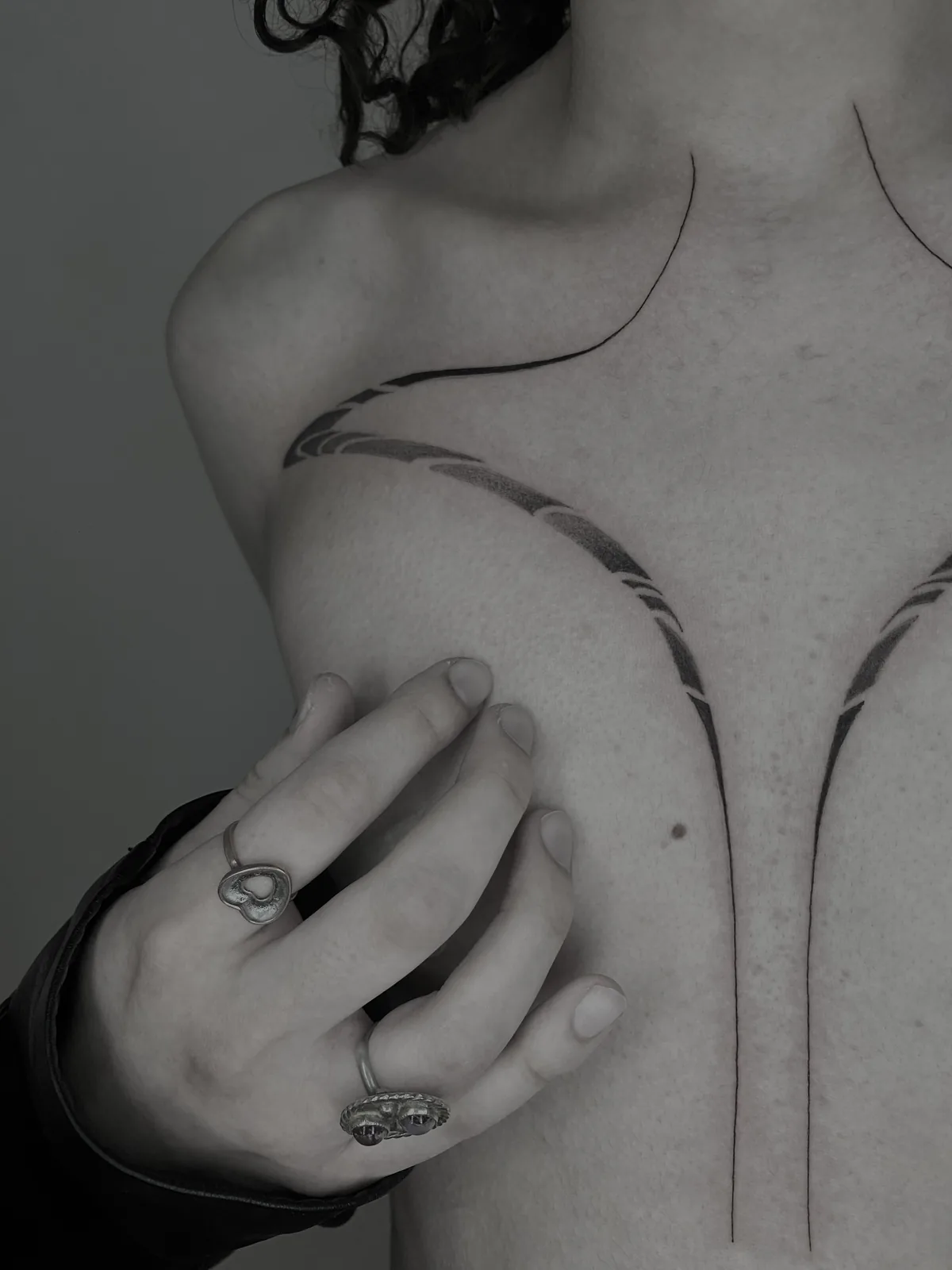 Fine-line contour lines across the collarbones and shoulders, GAR Tattoo