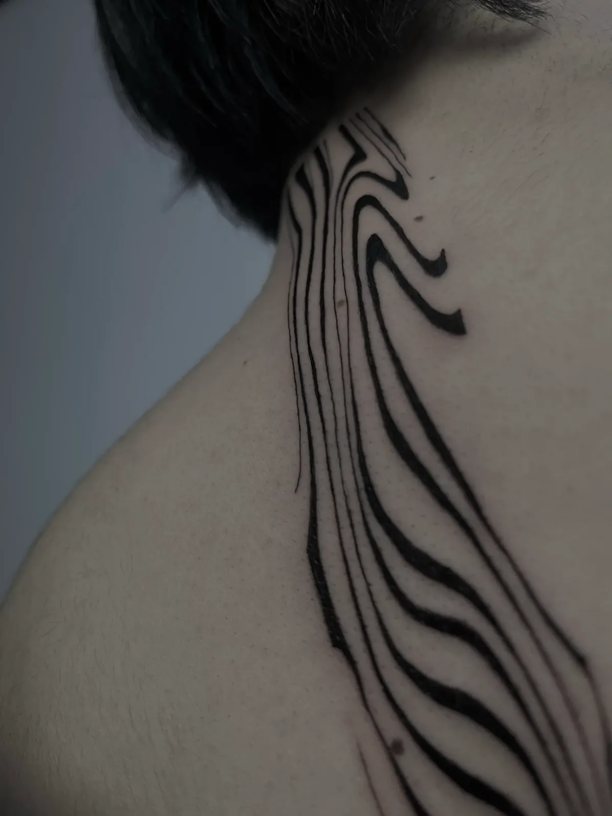 Liquid fine-line waves down the side of the neck and shoulder, GAR Tattoo