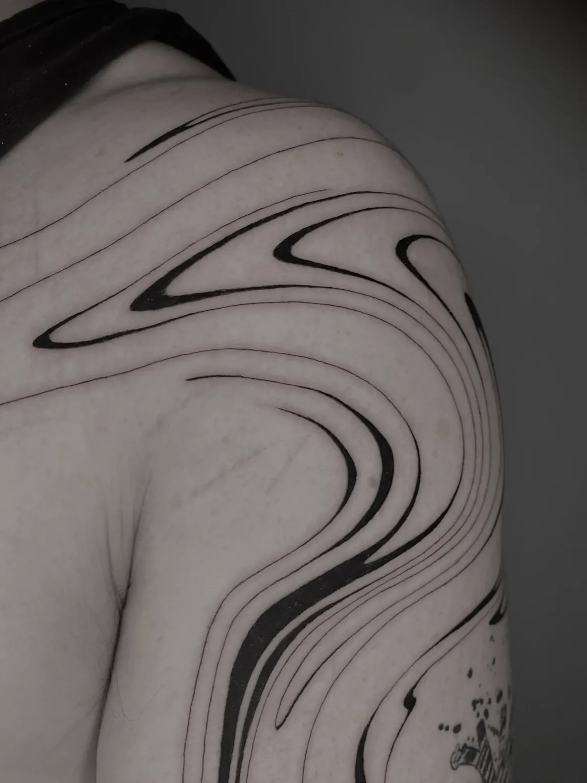 Liquid fine-line waves flowing across the shoulder and back, GAR Tattoo