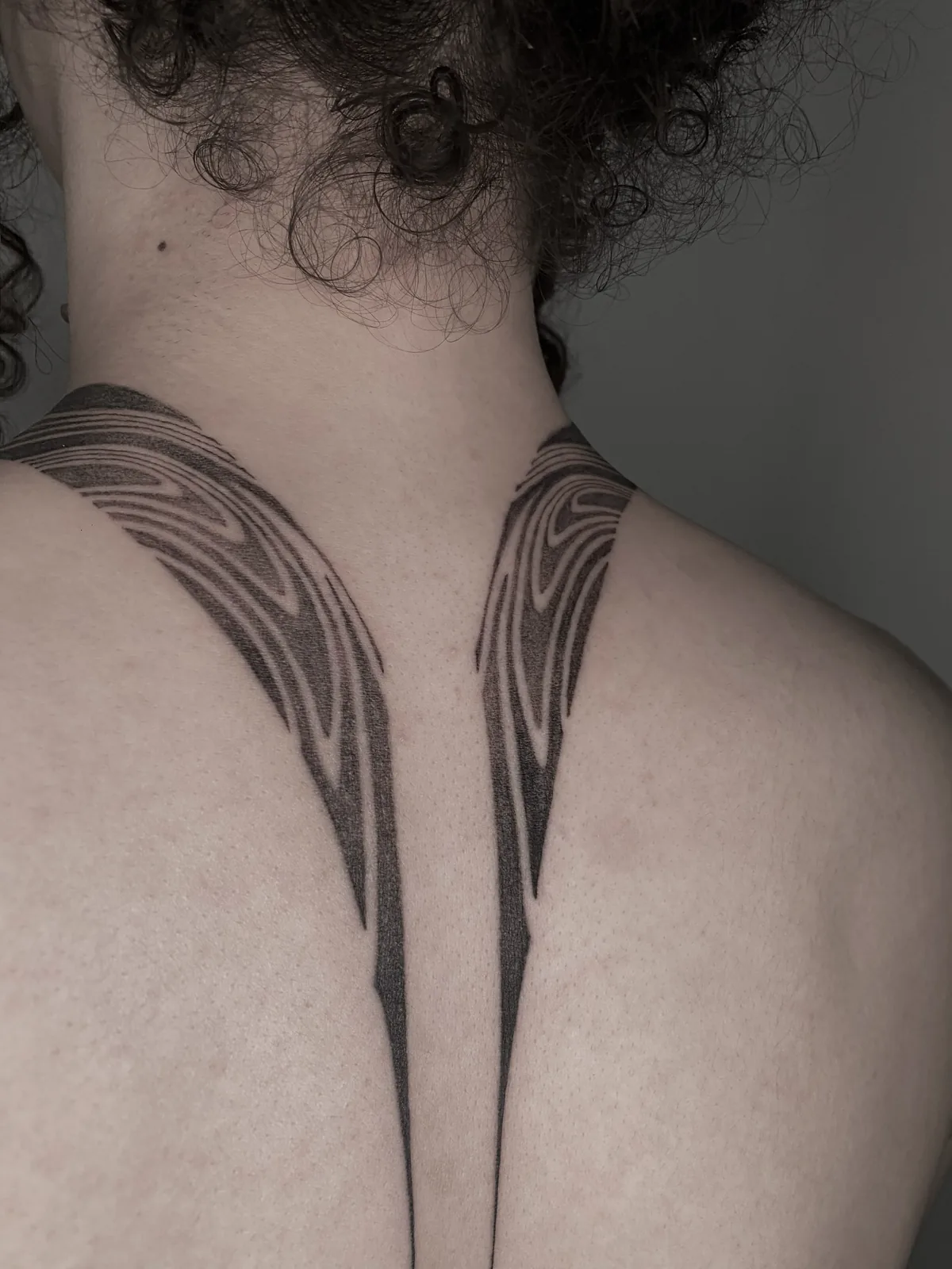 Symmetric fine-line wings across the nape and upper back, GAR Tattoo