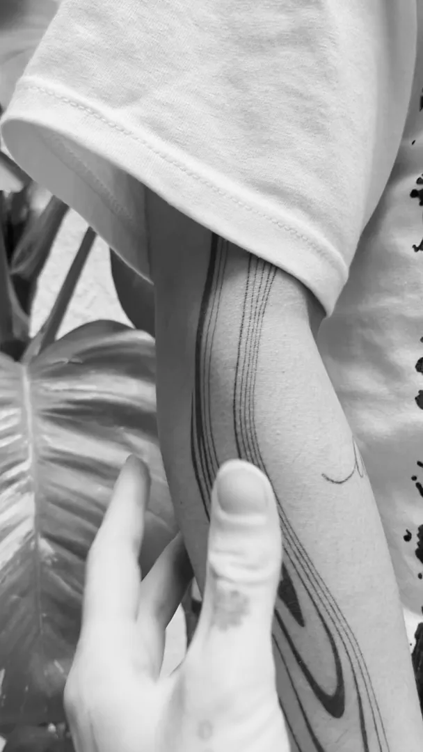 Healed liquid fine-line arm piece shown in motion, GAR Tattoo